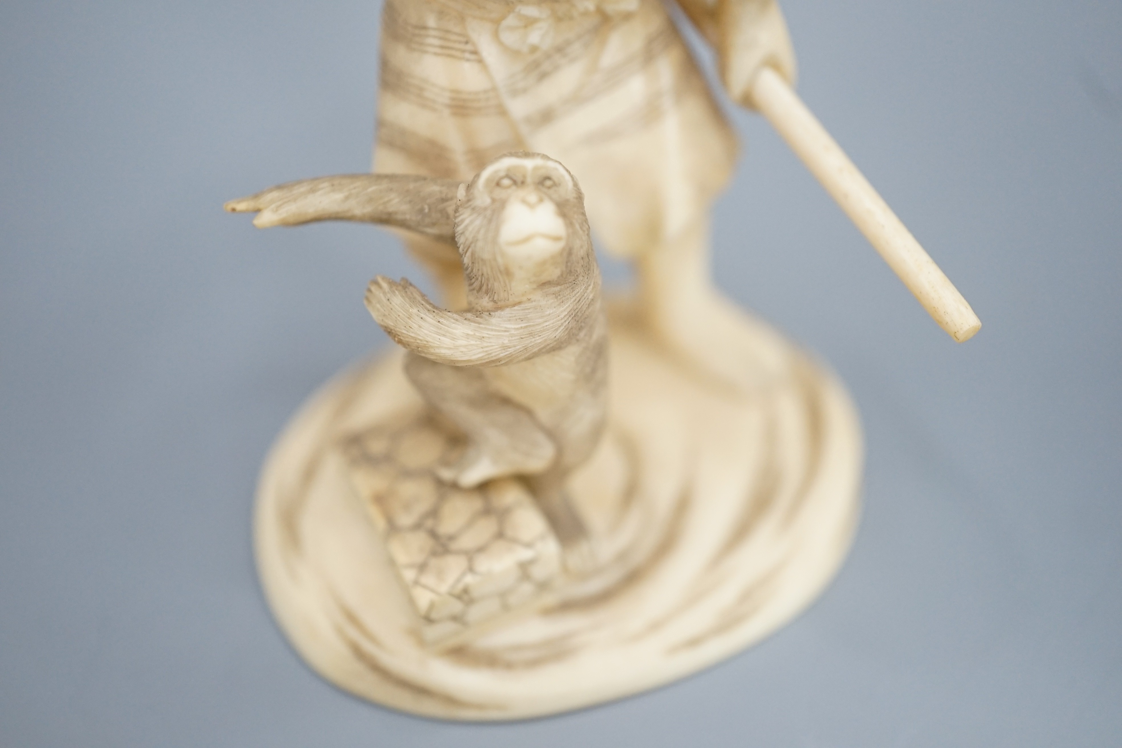 A Japanese ivory okimono of a monkey trainer, signed, Meiji period, 7.7 cm